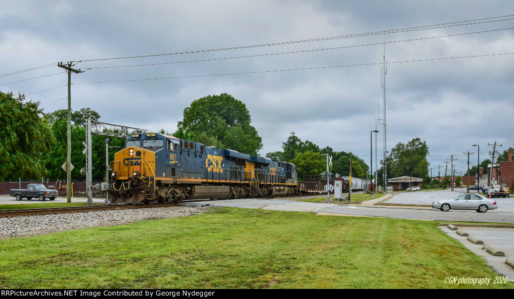 A long freight train passing thru town